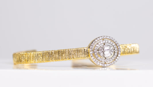 Gold bangle bracelet with silver stone